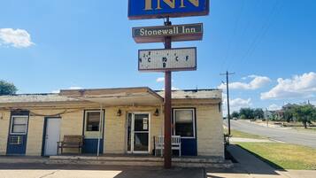 Un edificio con un letrero que dice "Budget Inn" y "Stonewall Inn", con un pequeño cartel debajo.