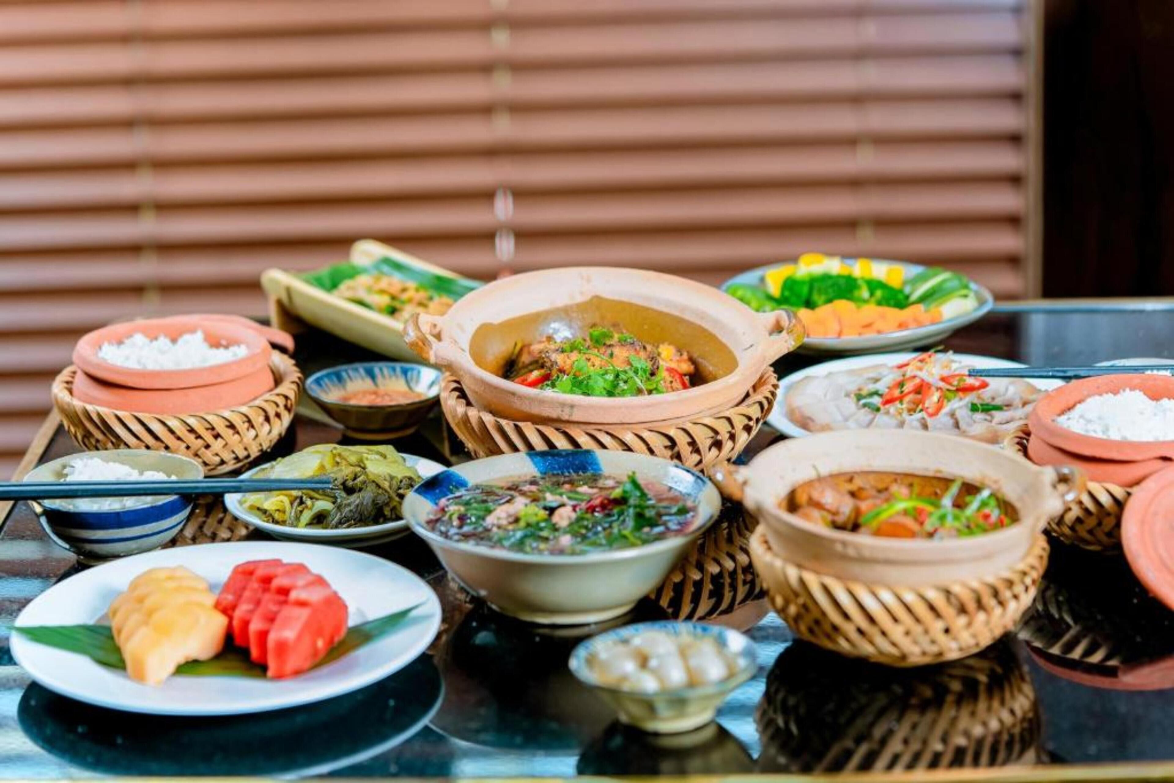 A table with various dishes, including bowls of soup and plates of food, arranged on a table.