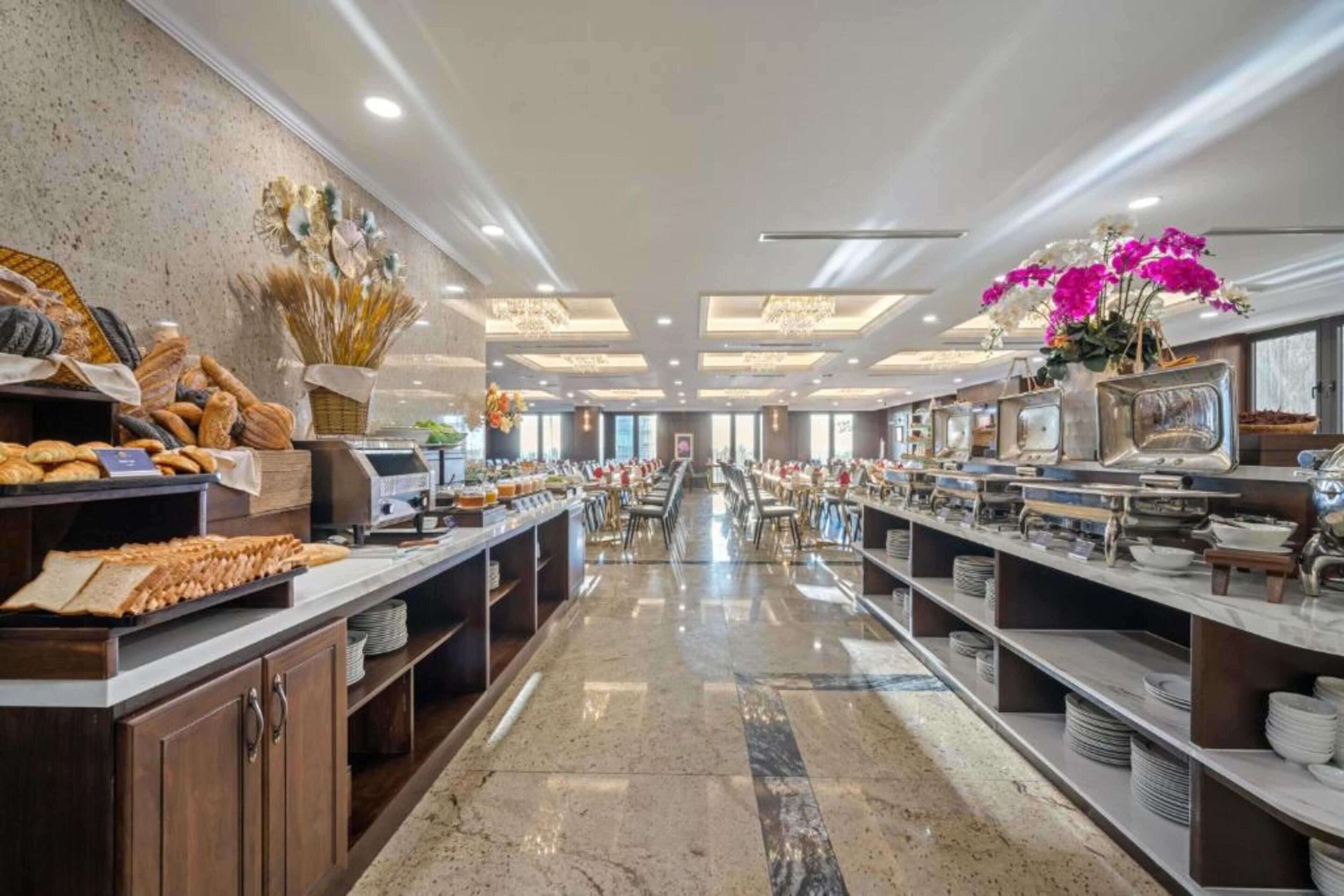 Amplia zona de buffet con múltiples estaciones de comida y una larga barra.