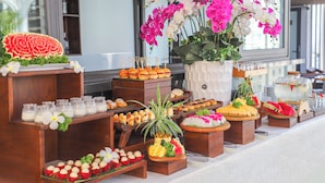 A buffet with various food items and a large floral arrangement. - Golden Lotus Luxury Hotel Da Nang (Da Nang)