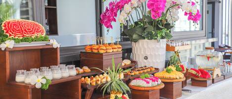 Un buffet proposant une variété de plats et agrémenté d’un grand arrangement floral.