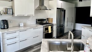 Eine moderne Küche mit weißen Schränken, Edelstahlgeräten und einem eingebauten Backofen.