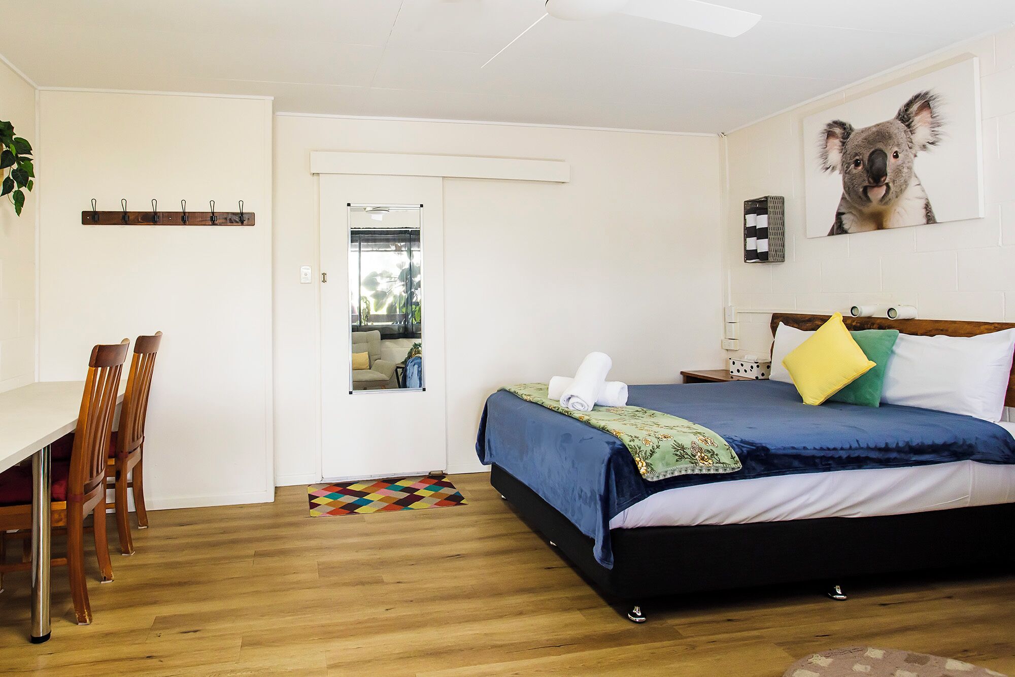 A bedroom with a bed, a desk, and a chair.