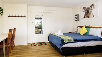 A bedroom with a bed, a desk, and a chair.