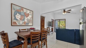 A dining area with a wooden table and chairs, a ceiling fan, and a view of the outdoors. - Amazing Condo! Playas del Coco (Provincia de Guanacaste)