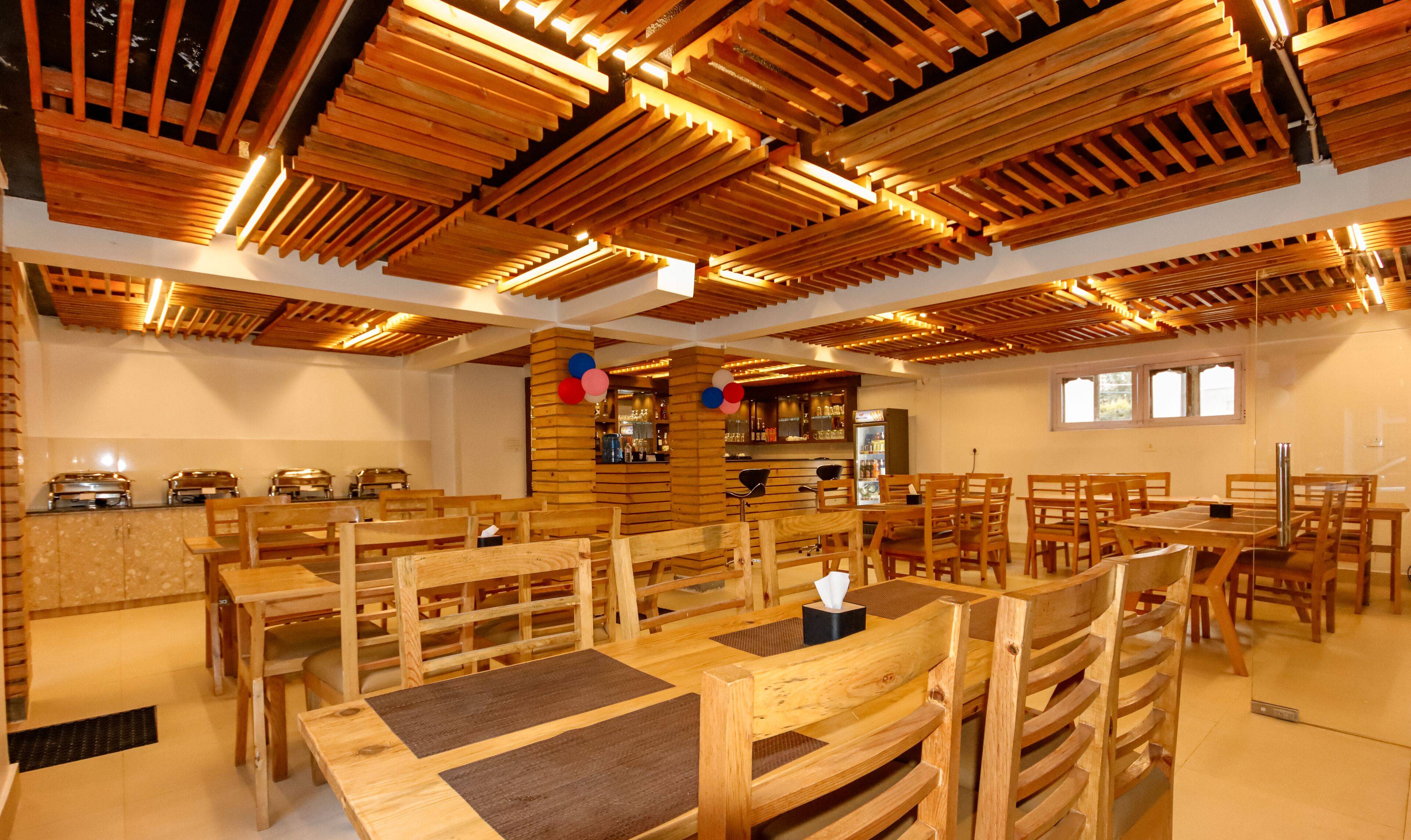 A restaurant with wooden furniture and a bar area.