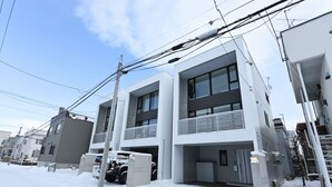 A modern residential building with a flat roof, large windows, and a covered parking area. - S12 HOTEL (Sapporo)