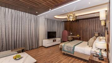 Une chambre d’hôtel moderne avec un plafond en bois, un grand lit, une télévision, un bureau et un coin repas.