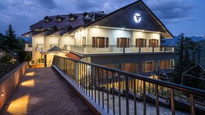 A multi-story hotel with a balcony, a staircase, and a view of the surrounding landscape. - Fortune Khajjiar - Member ITC Hotels' Group (Chamba)