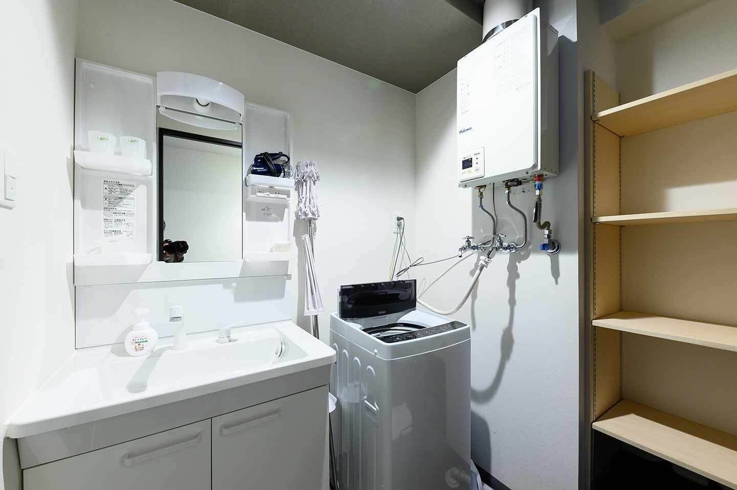 A bathroom with a white sink, mirror, and a wall-mounted heater.