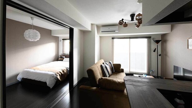 Une chambre d’hôtel moderne équipée d’un lit, d’un canapé, d’une table à manger et d’un ventilateur de plafond.