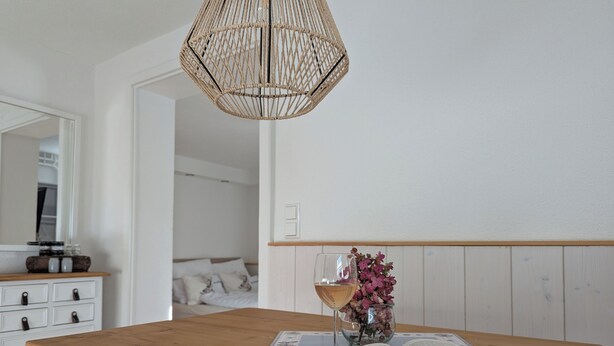 A bedroom with a wooden bedside table, a book, a pair of glasses, and a glass of wine. - Ferienwohnung "s' Stüble" mit ca 35qm - Die-uebernachterei (Hüfingen)