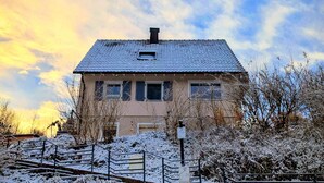 A house with a tiled roof, a chimney, and a small window. - Ferienwohnung "s' Stüble" mit ca 35qm - Die-uebernachterei (Hüfingen)