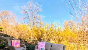 An outdoor seating area with wicker furniture, a coffee table, and decorative pillows. - Ferienwohnung "s' Stüble" mit ca 35qm - Die-uebernachterei (Hüfingen)