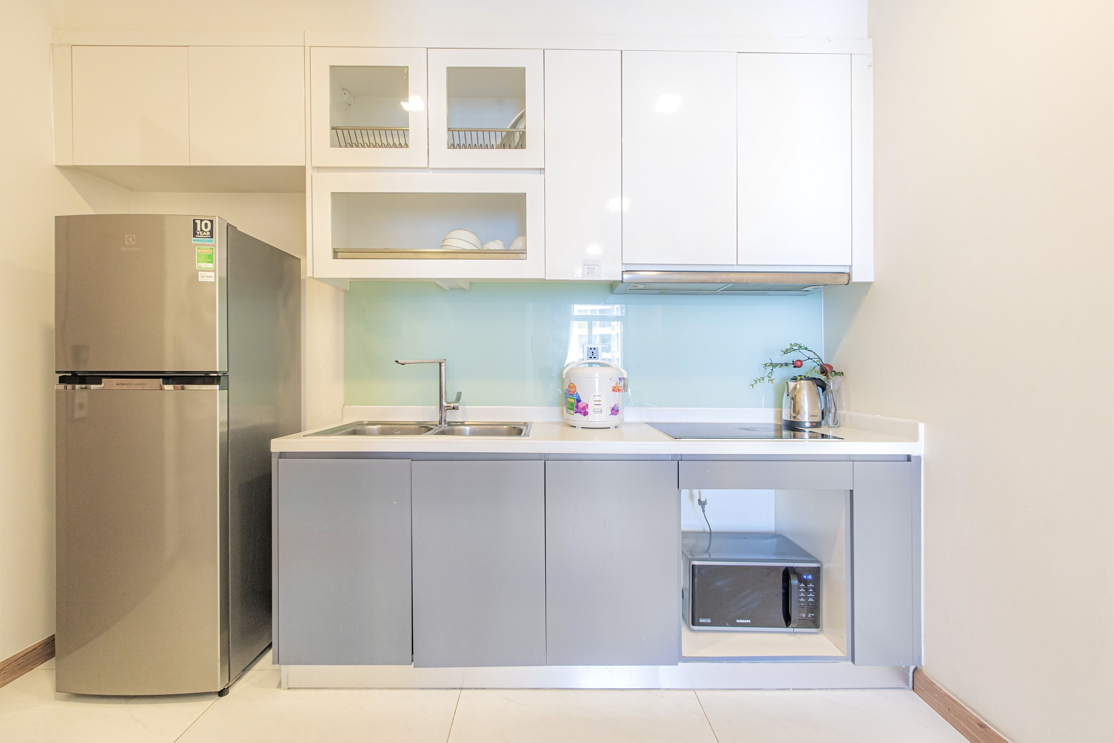 A compact kitchen with a built-in refrigerator, a microwave, and a coffee maker.