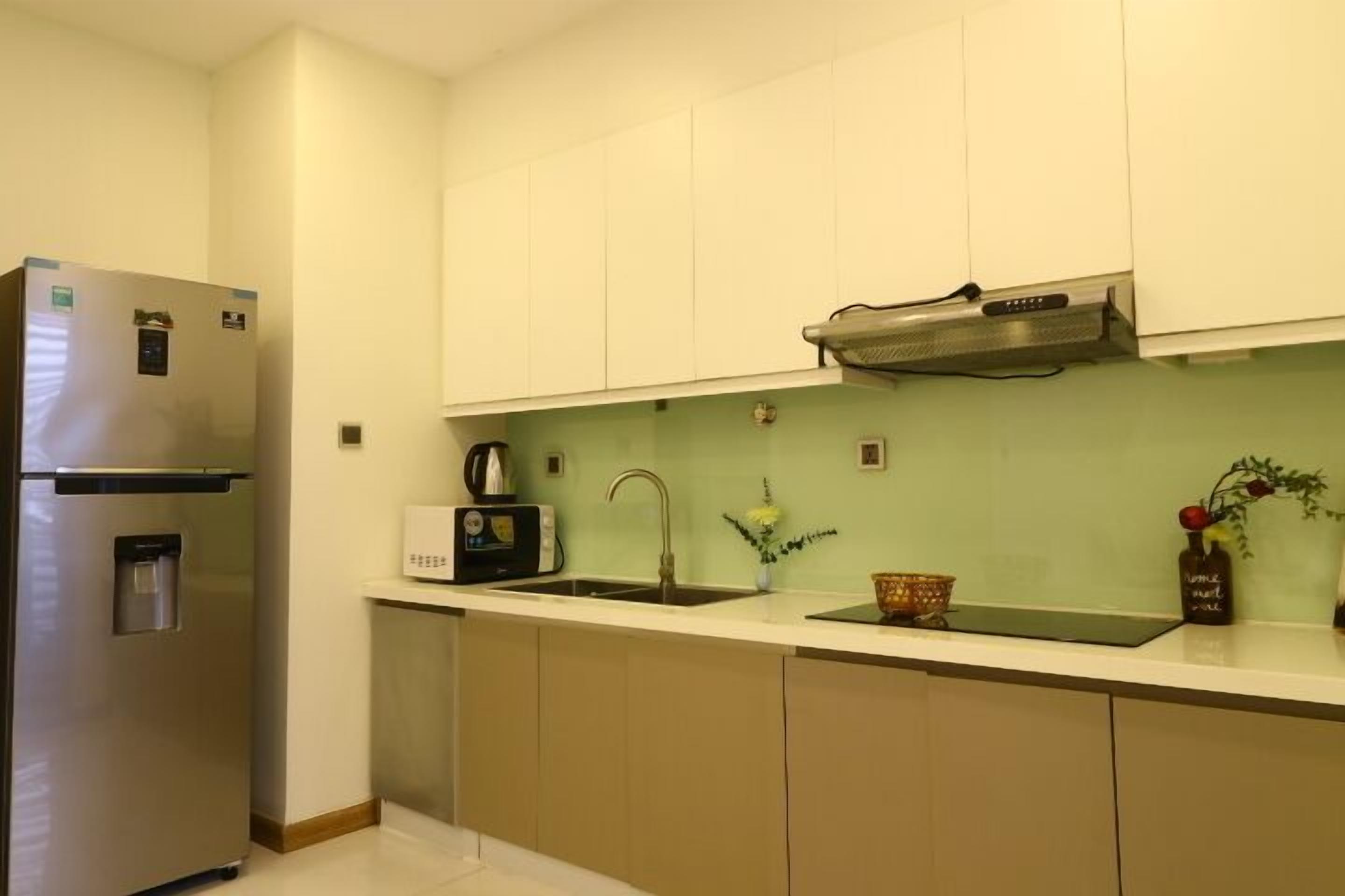 A compact kitchen with a built-in refrigerator, a toaster, and a sink.