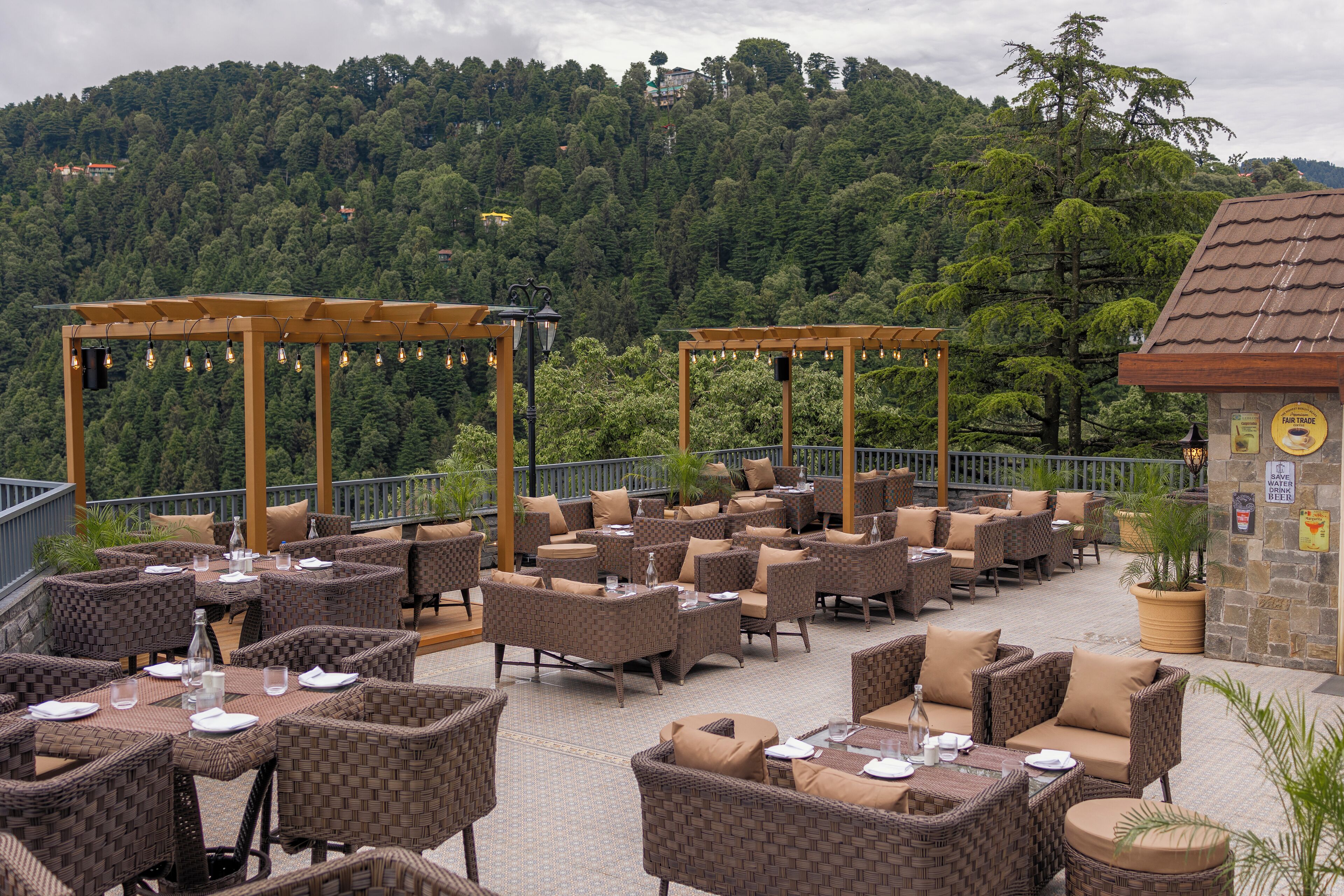 Un patio al aire libre con muebles de mimbre y una pared de piedra con un cartel.
