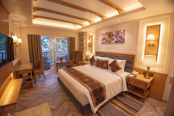 Ein geräumiges Hotelzimmer mit einem großen Bett, einem Schreibtisch und einem Balkon mit Blick.