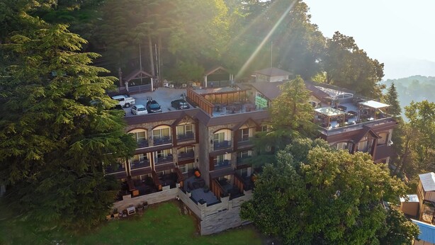 A multi-story hotel with balconies, a swimming pool, and a view of the surrounding forest. -  Presidium Sarovar Premiere Dalhousie (Dalhousie)
