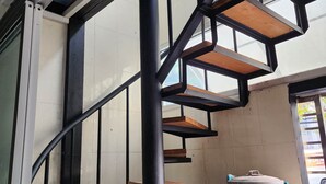 A staircase with wooden steps and black metal railings, leading to a higher floor. - Lo-ha Guesthouse Contactless Check-in (Bangkok)