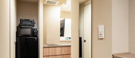 A compact kitchen with a microwave, stove, and cabinets.