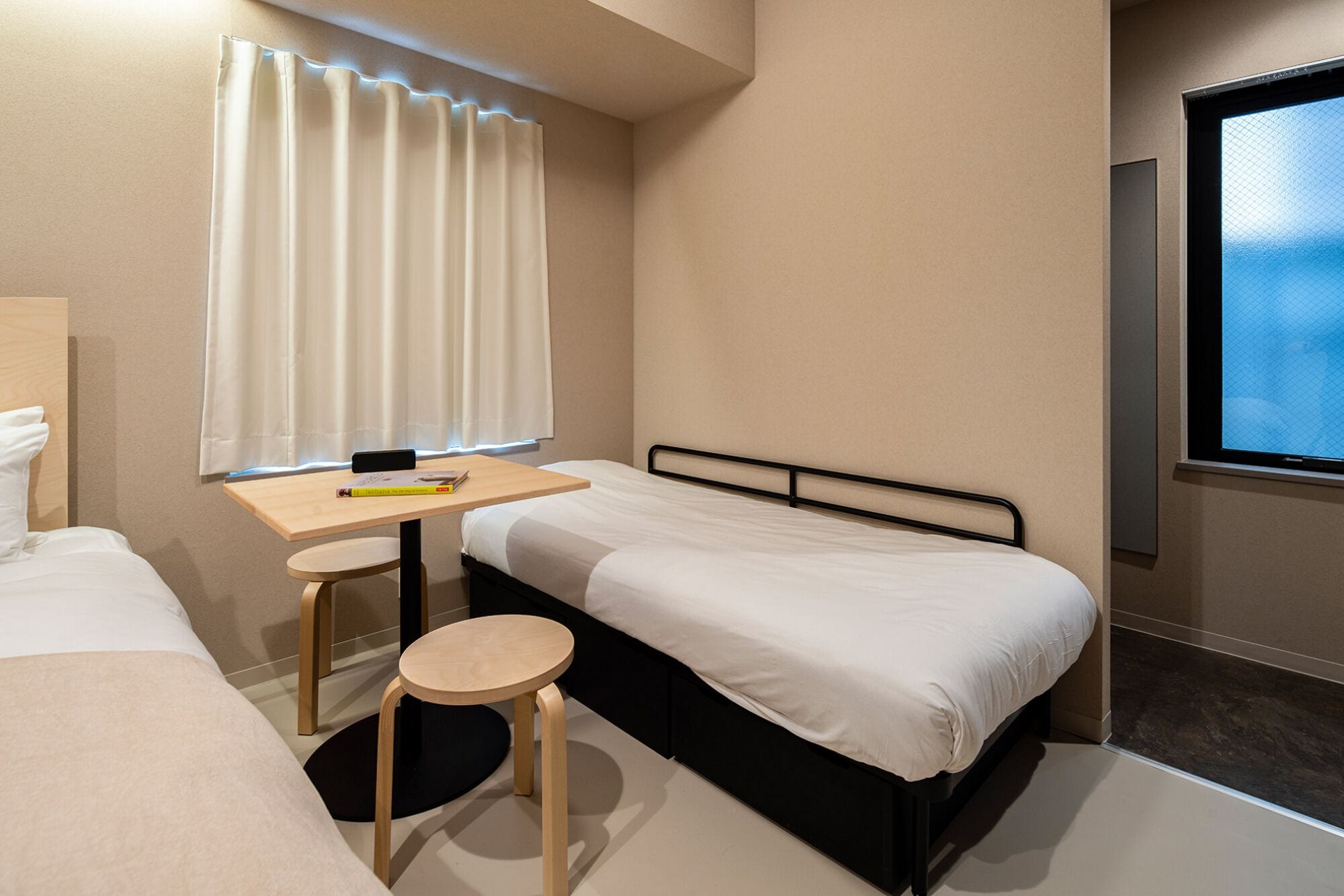 A hotel room with a bed, a desk, and a chair.