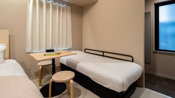 A hotel room with a bed, a desk, and a chair.