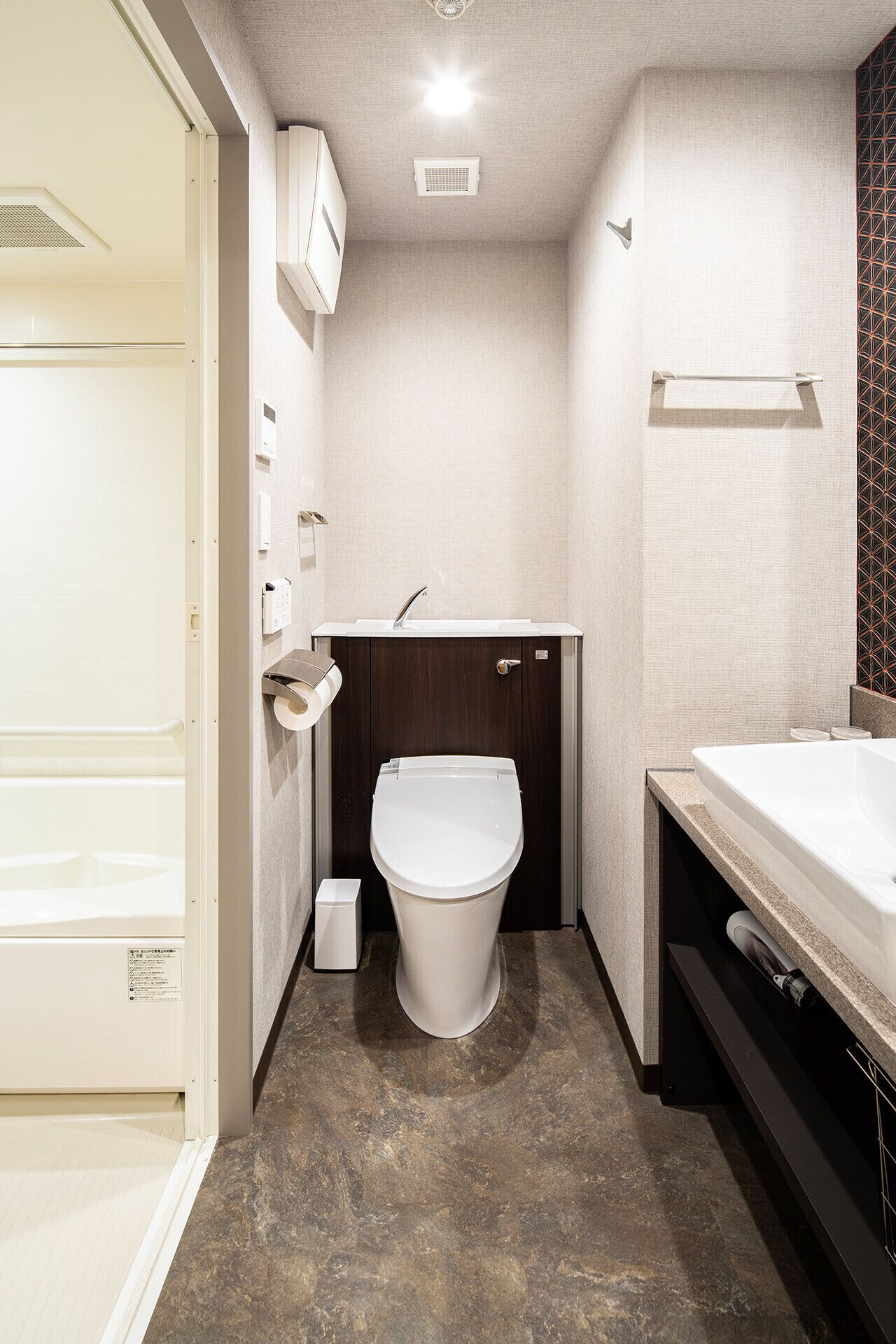 A compact bathroom with a toilet, sink, and shower area.