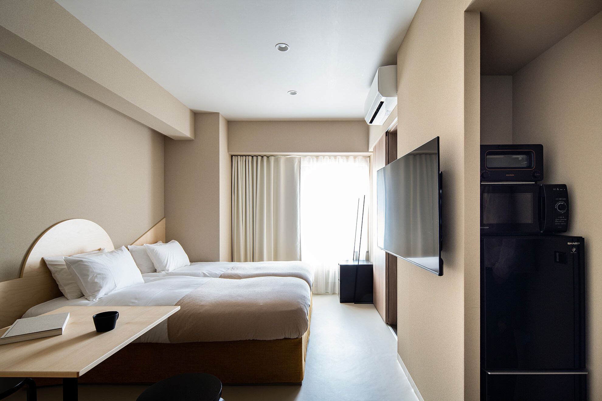 A hotel room with a bed, bedside table, and a TV.