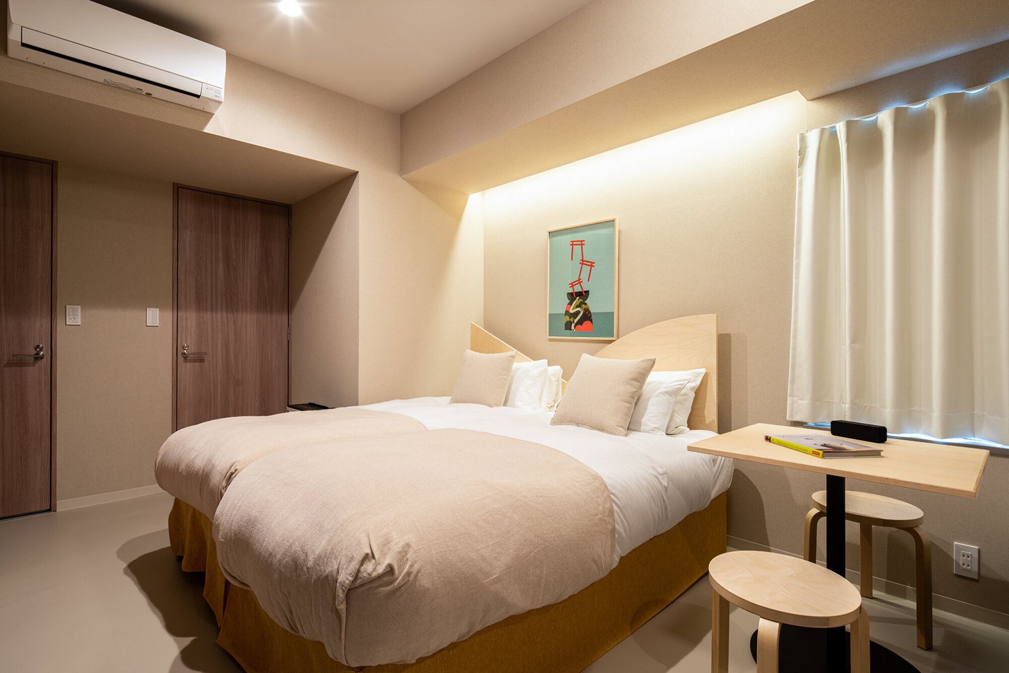 A modern hotel room with a large bed, a desk, and a window with curtains.