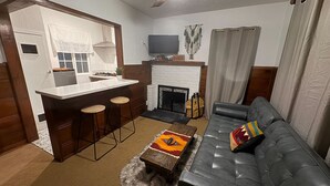 Una sala de estar moderna con chimenea, un sofá y una zona de bar.