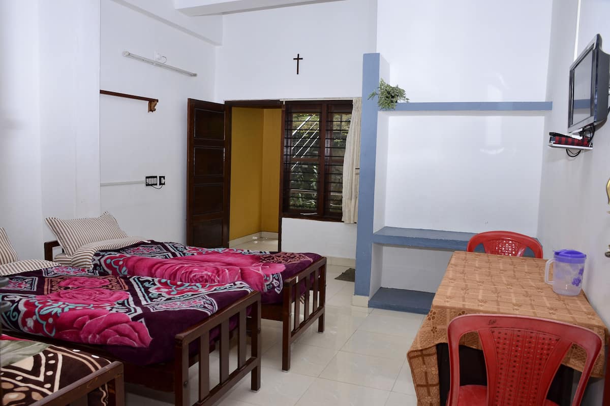 Una habitación pequeña y limpia con cama, mesa y televisor.