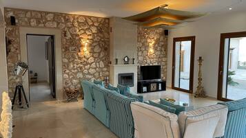 Una Smart TV, una chimenea, libros, un reproductor estéreo