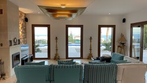 TV connectée, cheminée, livres, chaîne hi-fi