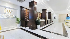 Eine moderne Lobby mit einer Rezeption, Topfpflanzen und einem sauberen, polierten Boden.