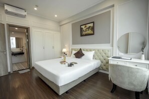 Hotelkamer met een bed, een kaptafel met spiegel, een schilderij aan de muur en een airconditioning.