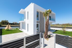 Een modern huis met twee verdiepingen, een plat dak, grote ramen en een balkon.