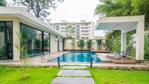 A modern outdoor swimming pool with a clear view of the surrounding buildings and greenery. - NAIRO STUDIOS (Nairobi)