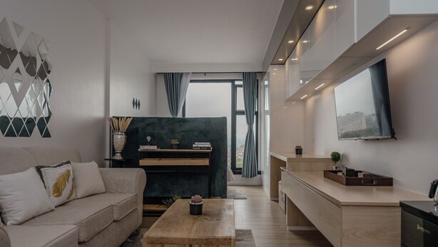 A modern living room with a sofa, coffee table, and a TV mounted on the wall. - NAIRO STUDIOS (Nairobi)