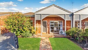 A residential building with a brick facade, a front porch, and a well-maintained lawn. - Cozy Newtown 2 bedroom unit (Newtown)