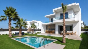 A modern two-story house with a swimming pool, palm trees, and outdoor furniture. - Martini Villas - Rosemary in Kremasti (Κρεμαστή)