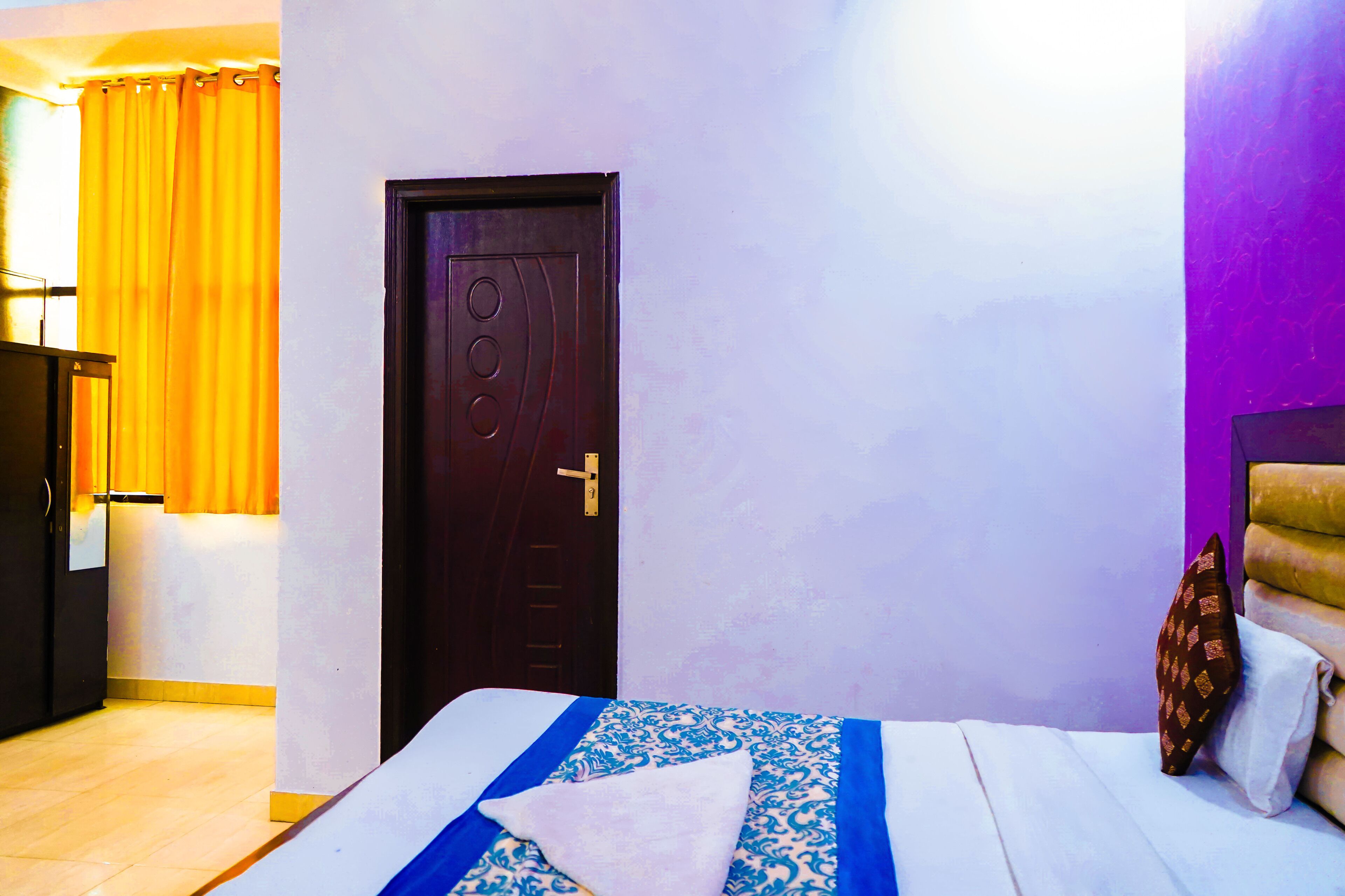A room with a bed, a door, and a curtain.