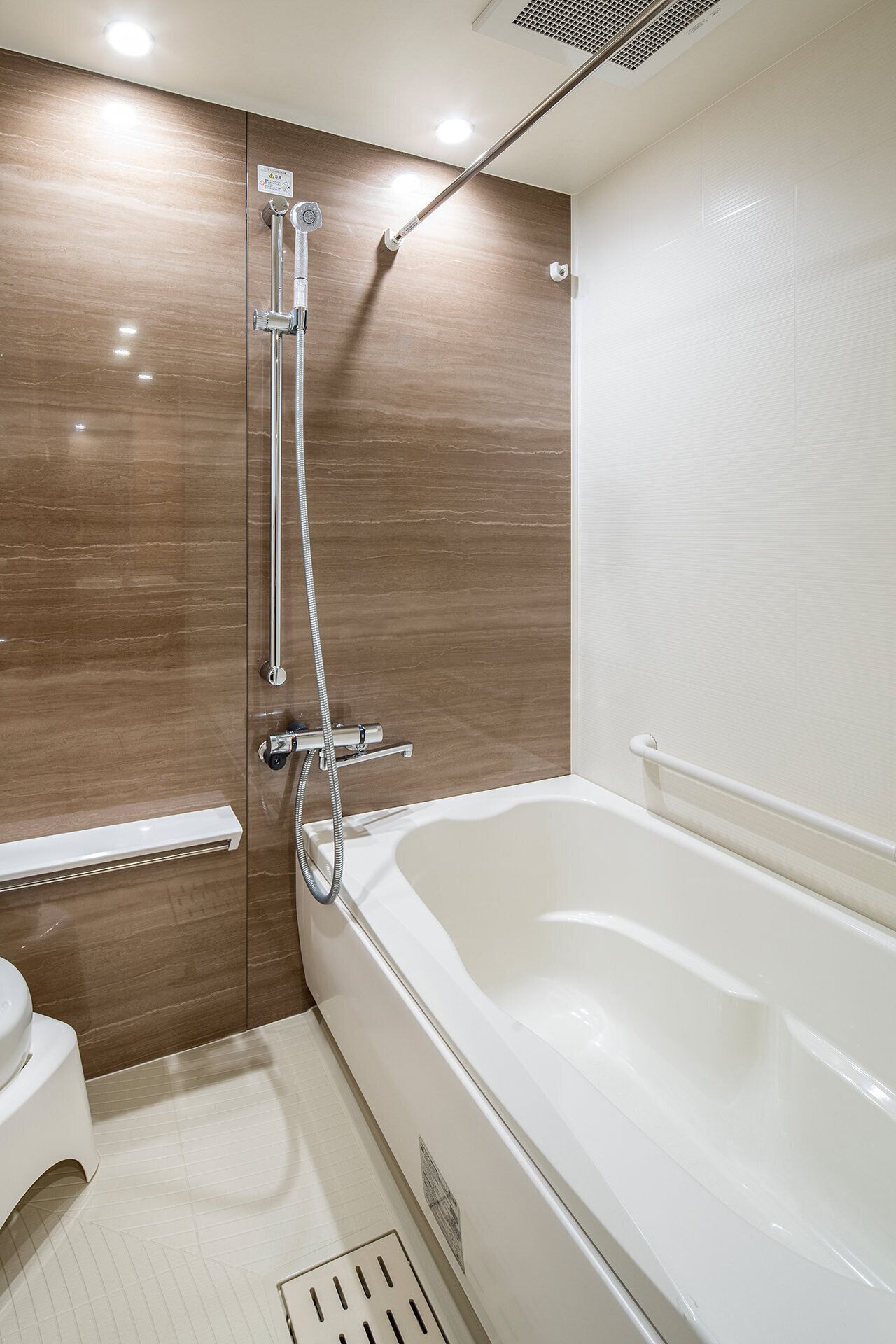 A modern bathroom with a bathtub, shower, and toilet.