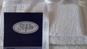 Une serviette blanche, soigneusement pliée, avec une étiquette « Je folo » et un ruban.