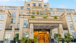 A large, beige building with a prominent entrance and a sign reading "CASINO THE VENICE HOTEL". - The Venetian Hotel   (Lusaka)