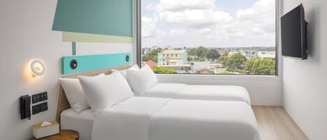 A modern hotel room with a large window, a bed, a bedside table with a tissue box, a wall-mounted TV, and a small lamp.