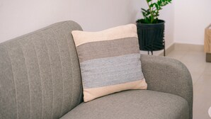Un canapé gris avec un coussin à rayures beiges et grises.