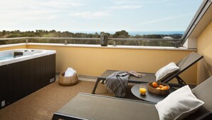A balcony with a hot tub, lounge chairs, a table with a basket of oranges, and a view of the sea. - Modern apartment with hot tub (Poreč)