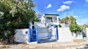 A modern building with a white exterior, a blue gate, and a balcony. - La Casa Di Alice sea view (Domus de Maria)