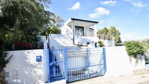 A modern building with a white exterior, a blue gate, and a balcony. - La Casa Di Alice sea view (Domus de Maria)